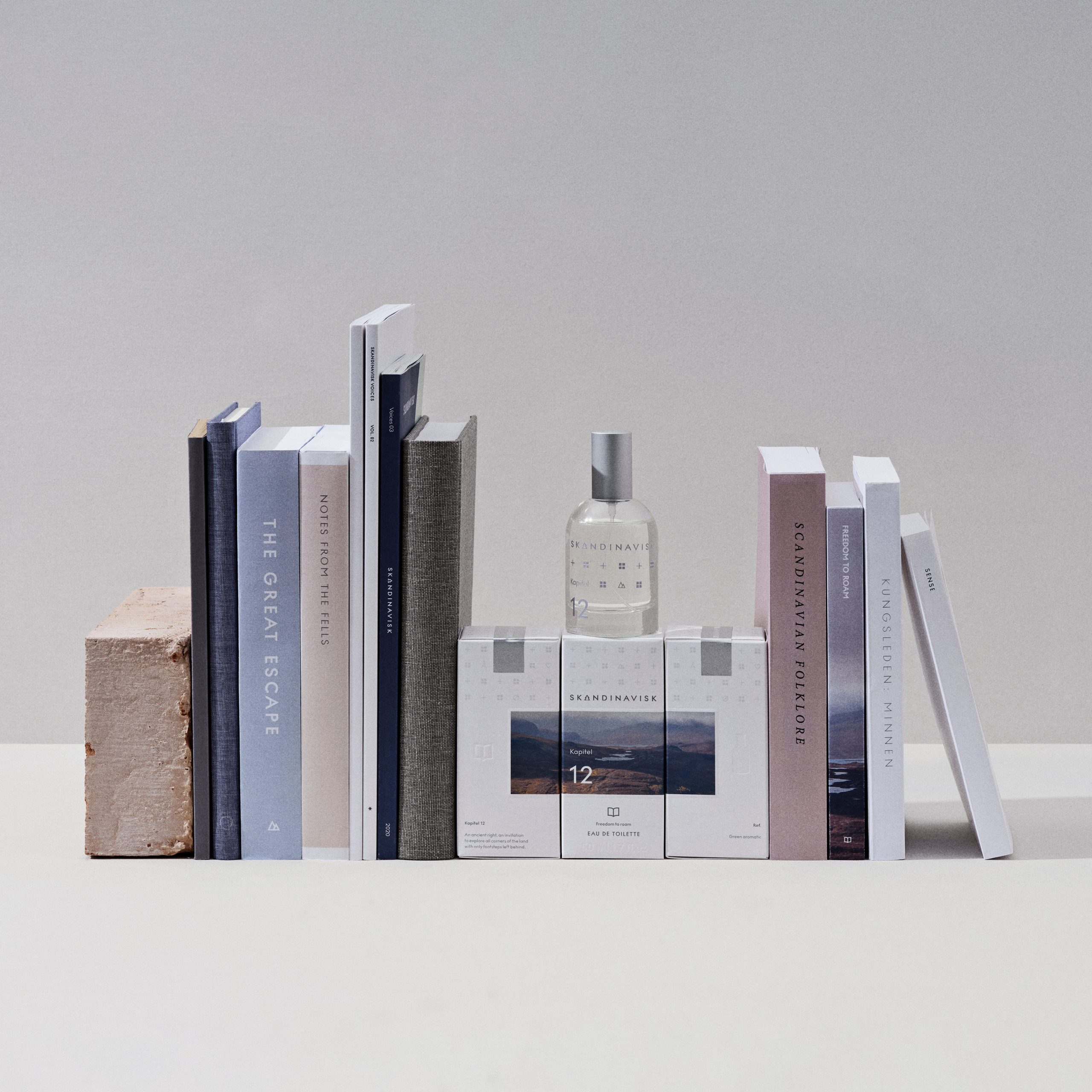 Skandinavisk’s Kapitel 12 perfume on a shelf surrounded by Scandinavian books