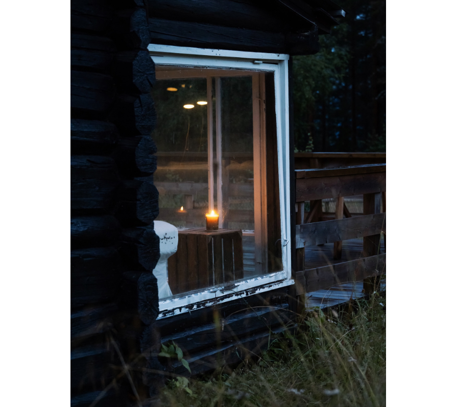 A single candlelight glows through the window — a quiet welcome home.